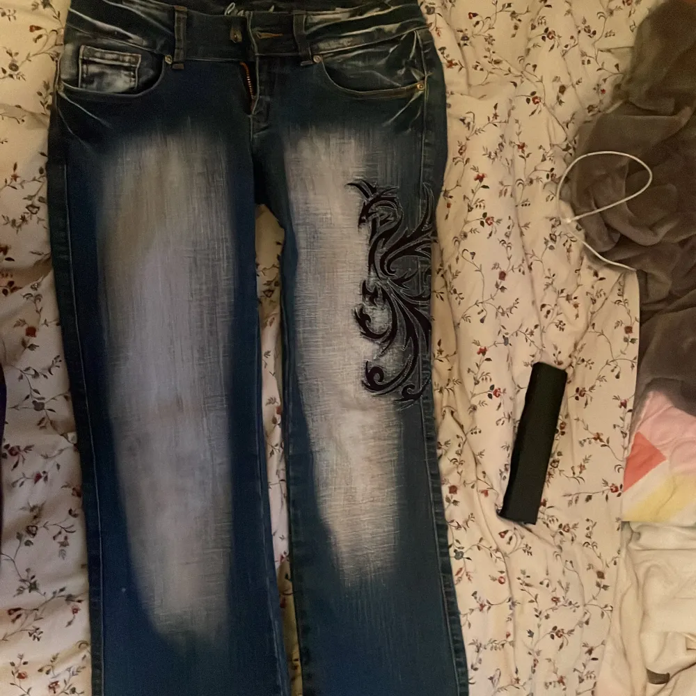 Snygga blå jeans från Crazy Age med coola broderade detaljer på framsidan och bakfickorna. De har en klassisk femficksdesign och dragkedjor på bakfickorna för extra stil. dm för flera bilder eller frågor! st38 men passar 36. Jeans & Byxor.