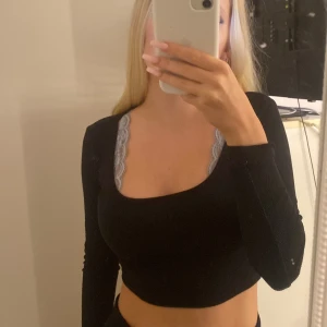 Svart croppad topp - Säljer en svart croppad topp med lång ärm. Toppen har en tight passform och är perfekt för både vardag och fest. Den är stilren och enkel att matcha med olika outfits. 
