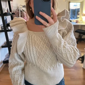 Beige stickad tröja med volangdetaljer - Flätstickad beige tröja med volanger över axlarna💓