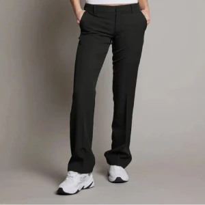 Svarta kostymbyxor - Snygga svarta kostymbyxor med en klassisk design. De har en rak passform och är perfekta för en stilren look. Byxorna har knappar och dragkedja framtill. Populärs vera low waist modellen💖 38