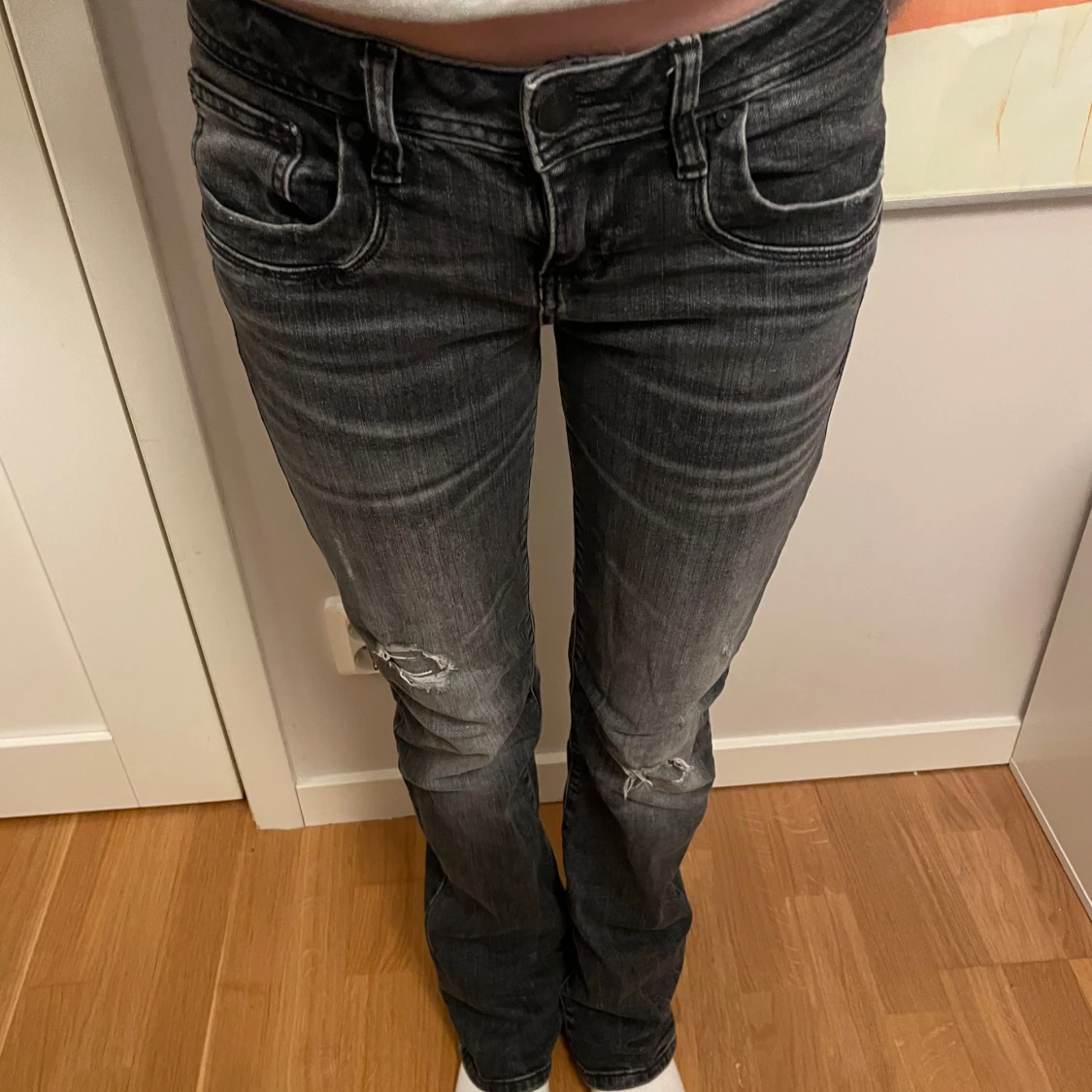 Svarta jeans med slitningar