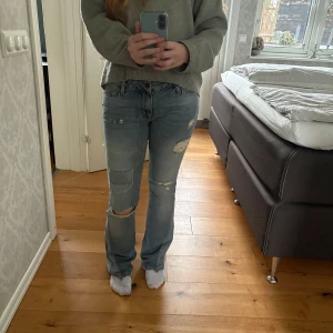 Blå jeans med slitningar - Skitsnygga omsydda jeans med slitningar på knäna och låren.                                                              Mått                                                                                Innerbensmått 82 cm                                                  Midjemått rakt över 41 cm                                                  Hör av er vid frågor eller funderingar💕