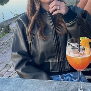 bomberjacka - Croppad bomberjacka med dragkedja framtill i en svart/grön/grå färg! Konstläder