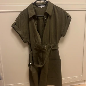 Olivgrön klänning med bälte från zara  - Snygg olivgrön klänning med korta ärmar och knappar framtill. Jag har klänning från zara för 500kr. Fråga mig om ni har några frågor💗