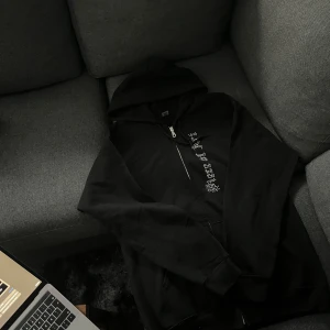 Svart rhinestone hoodie med dragkedja - Helt ny. Säljer en stilren svart rhinestone hoodie med dragkedja framtill. Perfekt för en avslappnad look. Den har en klassisk passform och en bekväm huva. Passar bra till både jeans och joggers.