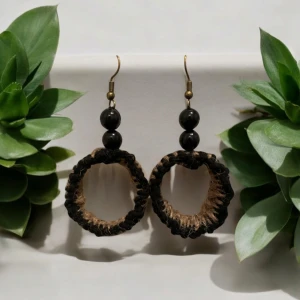 Rustika örhängen med svarta pärlor - Unika handgjorda örhängen med en rustik känsla. De har svarta pärlor och en cirkulär design i naturmaterial. Perfekta för att ge en bohemisk touch till din stil.