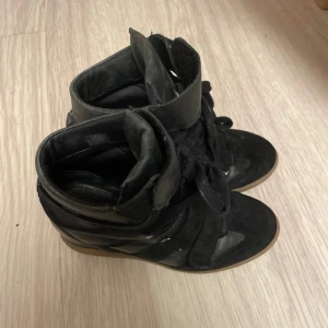 Svarta isabel marant - Snygga svarta sneakers med kilklack och snörning. Har bara haft de på en eller två gånger. säljer eftersom dem inte har använts