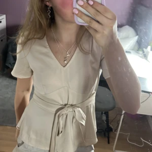 Beige blus med knytband - Super fin v-ringad blus som inte kommer till användning längre❤️ banden går att knyta både fram och bak!❤️ skriv för frågor!!💫💫