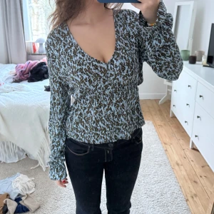 Blus med mönster - V-ringsd blus med blommor. Använd fåtal gånger och i bra skick! I storlek M men är insydd lite vid midja, skulle dock fortfarande säga att den passar storlek M/S.