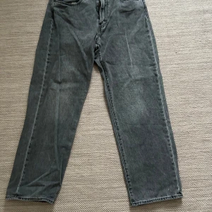 Grå Levis jeans - Säljer ett par grå Levis jeans i mycket bra skick. W34/L32, de har en loose fit och är perfekta för en avslappnad stil. Klassisk femficksdesign med dragkedja och knapp. Passar perfekt för både vardag och fest. Sköna och stilrena!