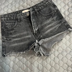 Svarta jeansshorts från Cropp - Säljer ett par snygga svarta jeansshorts från Cropp i storlek XS. De har en stockholmstil look med fransiga kanter. Perfekta för sommardagar eller festivaler! 🖤