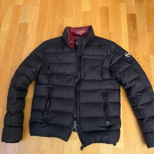 Svart pufferjacka från Colmar - Säljer en snygg svart pufferjacka från Colmar i mycket bra skick. Jackan har en quiltad design med dragkedja och långa ärmar. Insidan är färgglad med röd, vit och blå nyanser.storleken är 46 vilket motsvarar S/M. Perfekt för höst och vinter! Två lagade pinch Hole på undersidan av armen vilket gör det svårt att se, kan även tänka mig att byta mot något i samma storlek. Hör av dig vid fler frågor mvh Emil.