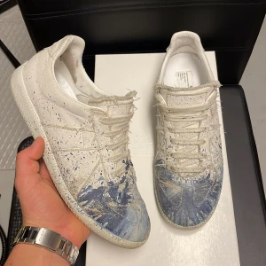Maison margiela gats - Säljer nu dessa extremt feta maison margiela gats med blå paint split! Storlek 41-42. Skick 8/10. Box samt skopåsar tillkommer! Kan gå ner i pris vid snabb affär. Hör av dig vid minsta fundering !💯