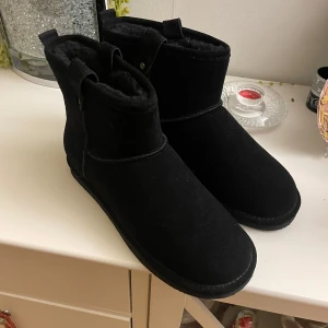 Svarta boots från Bianco - Säljer ett par svarta boots från Bianco i mycket bra skick. De är gjorda i mocka och har en mysig, fodrad insida som håller fötterna varma. Perfekta för höst och vinter! De har en enkel design utan snörning eller dragkedja, vilket gör dem lätta att ta på och av. Säljer dom då dom vart för stora☺️