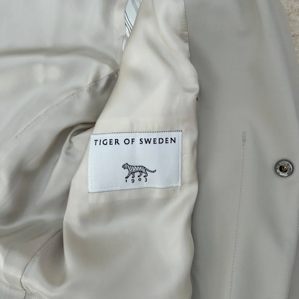 Säljer en stilren grå kappa från Tiger of Sweden. Perfekt för höst och vår, och ger en elegant touch till vilken outfit som helst. Passar både till vardags och mer formella tillfällen. Skriv om ni har några frågor!. Jackor.