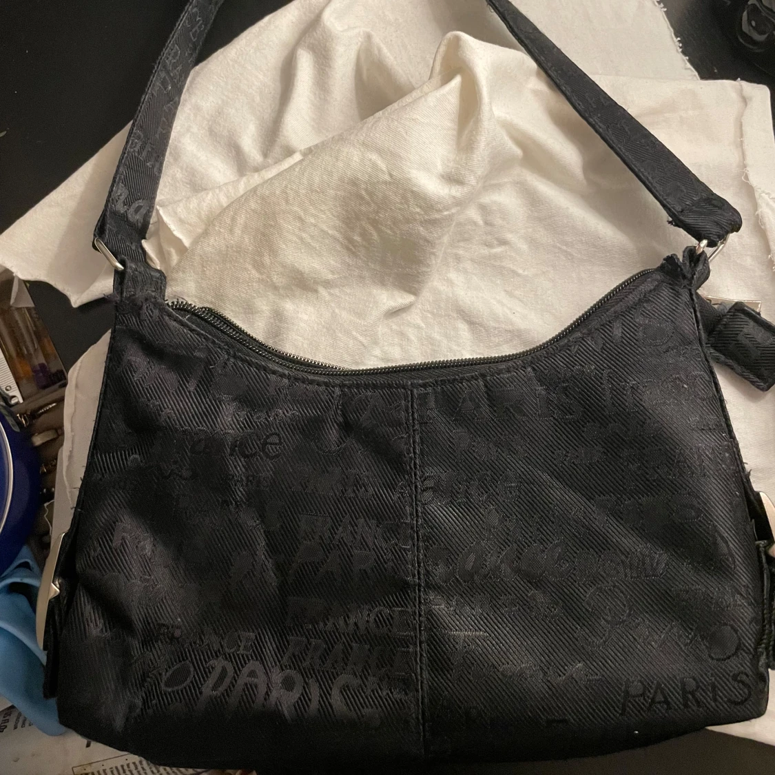 Svart axelväska med textmönster