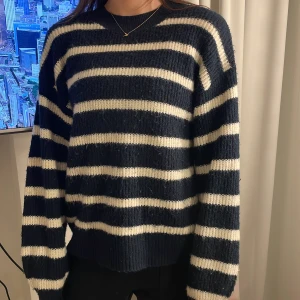 Randig stickad tröja - Säljer en supermysig randig stickad tröja i marinblått och vitt. Den har en avslappnad passform med långa ärmar och ribbade muddar. Perfekt för kyliga dagar och att mysa i hemma. Passar både till jeans och kjol! Lite använd och tvättad men fortfarande bra skick❤️