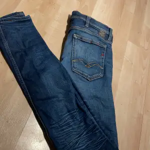 Säljer ett par snygga blå jeans från Replay i storlek W30. De har en klassisk femficksdesign med coola detaljer på bakfickorna. Jeansen är i bra skick och perfekta för både vardag och fest. Passar dig som gillar en stilren look med en touch av edge🤩