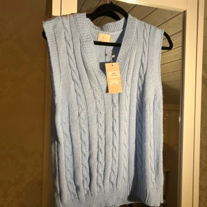 Ljusblå stickad väst - Säljer en superfin ljusblå stickad väst från Zara Knit. Den har ett snyggt flätmönster och är perfekt för lager-på-lager-stil. Västen är i nytt skick och passar till både vardag och fest. Perfekt för vår och sommar!