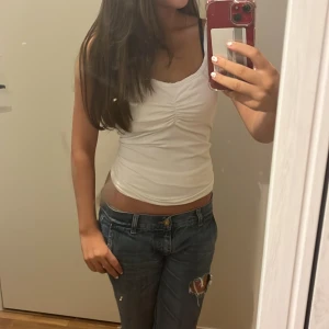 Vitt linne med rosett - Brandy melville liknande linne som är supersöt!I bilden har jag vikt upp nederdelen av linne för att få en lite magtröja❤️Perfekt för sommardagar eller som basplagg i garderoben. 