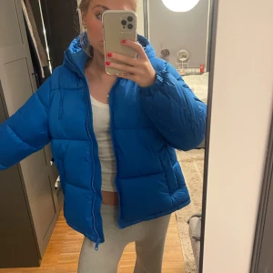 Blå pufferjacka - Säljer en snygg blå pufferjacka i mycket bra skick. Jackan är perfekt för kalla dagar med sin tjocka vaddering. Den är perfekt för både höst och vinter. Perfekt för att hålla sig varm!🩵❄️