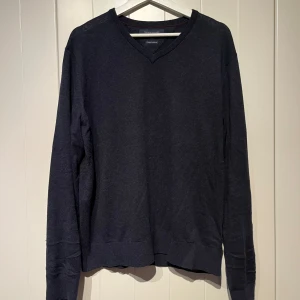 Mörkblå stickad kashmir tröja från Tommy Hilfiger - Säljer en stilren mörkblå v-ringad tröja från Tommy Hilfiger i storlek L som även passar M. Tröjan är gjord av en blandning av bomull och kashmir med padding på armbågarna. Tröjan är i mycket bra skick med nypris 2500:-