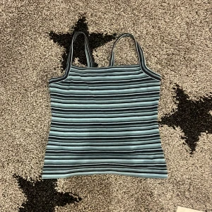 Randig linnetopp från L.O.G.G. Storlek s - Säljer en snygg randig linnetopp från L.O.G.G. i storlek S. Toppen har smala axelband och är i blå och svarta ränder. Perfekt för sommardagar eller som ett lager under en jacka. Den är i bra skick och redo för nya äventyr!