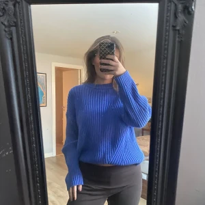 Blå ribbad tröja - Säljer en snygg blå ribbad tröja i mycket bra skick. Den har en normal passform och är perfekt för både höst och vår. Tröjan är långärmad och gjord i ett mjukt material som känns skönt mot huden. Perfekt för en casual look eller att klä upp med accessoarer!
