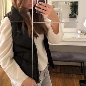 Svart dunväst - Säljer en svart dunväst i mycket bra skick. Perfekt för höst och vår, med en normal passform. Västen har en dragkedja framtill och är superfin att ha över en tröja🍂🧡