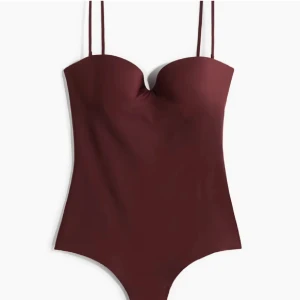 Vinröd body - Jätte snygg och trendig vinröd body som är oanvänd med prislappkvar. Helt slutsåld med en elegant bandeau-stil med avtagbara axelband och en smickrande passform. Tillkommer även med band som man kan sätta på om man vill. 💗