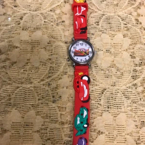 Cars barnklocka - Säljer en supercool barnklocka med ett färgglatt biltema. Klockan har en rund urtavla med tydliga siffror och ett armband med olika bilmotiv i rött, grönt, blått och lila. Perfekt för barn som älskar bilar och vill lära sig klockan på ett roligt sätt!  Nya batteri,  3 år +   115kr/st 