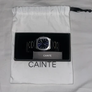 Cainte klocka - Cainte Claude Classic Blue Automatic. Väldigt fin och fräsch klocka. Nypris är lite över 8000kr och mitt pris är 4000. Köpt förra året i december så inte ens ett år gammal. Väldigt bra skick och knappt använd. Pris ej hugget i sten vid snabbaffär!