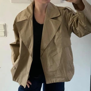 Gina Tricot kort trenchcoat - Kort trenchcoat från Gina Tricot som är slutsåld på hemsidan!  Märke - Gina Tricot Storlek - M Färg - Beige Material - Bomull Nypris - 699kr Skick - Nyskick med prislapp