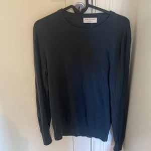 Mörkblå 100% Merinoulls tröja Tiger of Sweden - Säljer en stilren och klassisk mörkblå tröja från Tiger of Sweden. Den är gjord av 100% Merinoull, vilket gör den perfekt för kyligare dagar. Tröjan har en rund hals och långa ärmar, vilket ger en tidlös look. Passar både till vardags och lite finare tillfällen. Den är i nyskick och är M men passar även S. Tveka inte att höra av er vid funderingar. 