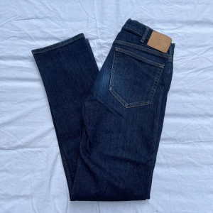 Gant jeans mörkblå - Använd och sämre skick. Gant jeans med mörkare blå färg. Patchen på baksidan har börjat bli lös. Säljer de för billigt pris. Först till kvarn, pris går att sänka! Butik pris: 1199kr