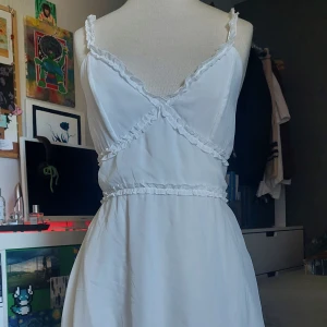 Söt vit sommarklänning - En söt vit sommarklänning, köpt på H&M inte använd så mycket. Har dragtjedja på sidan och knytning där bak, samt en öppen rygg. Parfect för en varm sommar eller för student firande.