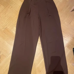 Brun byxa från Nelly - Mörkbruna byxor i storlek M från Nelly Trend. Använd men i gott skick. Normal i storleken <3