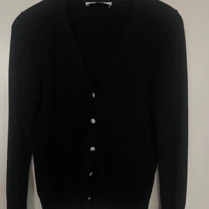 Svart kofta med glittriga knappar - Snygg svart kofta med glittriga knappar framtill. Långärmad och i en klassisk design som passar till det mesta. Den är från Zara💕