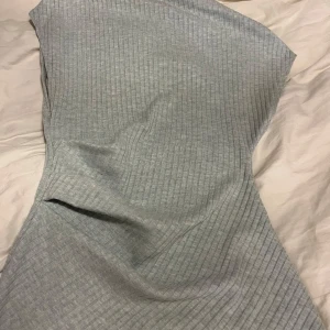 Ljusgrön ribbad topp från Zara - Snygg ljusgrön ribbad topp från Zara. Den har en oneshoulder-design som ger en trendig look. Perfekt för att styla med olika accessoarer. Toppen är tillverkad i ett mjukt och bekvämt material.