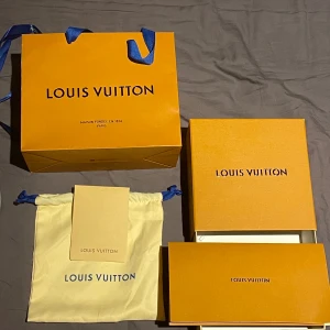 Svart bälte från Louis Vuitton - Snyggt svart bälte från Louis Vuitton med en stilren silverfärgad LV-logotyp som spänne. Perfekt för att ge en lyxig touch till din outfit. Kommer i originalförpackning med påse och låda. Kvitt medföljer!