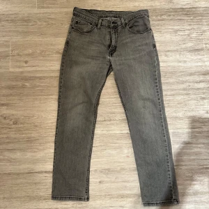 Grå jeans från Levi's - Snygga grå jeans från Levi's med klassisk femficksdesign och dragkedja. Perfekta för en avslappnad stil. De har en slim/skinny fit och är i W34 