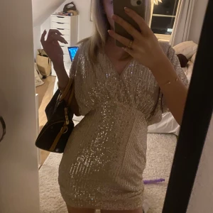 Glittrig kortklänning i silver - Snygg glittrig kortklänning i silver med v-ringad design och kortärmade ärmar. Perfekt för en kväll ute med vänner. Köpt på Shein för några veckor sedan för 130kr❤️ Säljer då passformen inte är som jag hoppades på mig