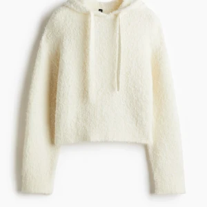 Vit fluffig hoodie - Mysig vit hoodie med fluffig textur och dragsko i huvan. Perfekt för kyliga dagar när du vill ha något bekvämt och stilrent. 