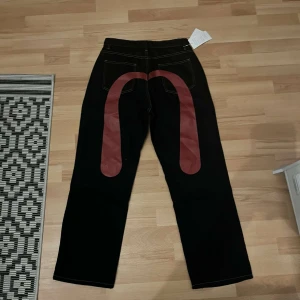 I;I Evisu jeans - Tjenare! Säljer dessa stilrena I;I r3pl1ka Evisu jeans med ett rosa M som motiv. Byxorna har en hyfsat bred passform och är perfekta för dig som vill sticka ut. Knappt använda, mycket bra skick. För mer bilder kom dm.