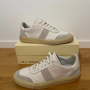 Vita och grå sneakers från Axel Arigato - Axel Arigato skor som jag knappt använt alls och tänker därför sälja av dom. Dom är i väldigt bra skick! Storlek 45. Kan såklart tänka mig att sänka priset vid en snabb och enkel affär!!