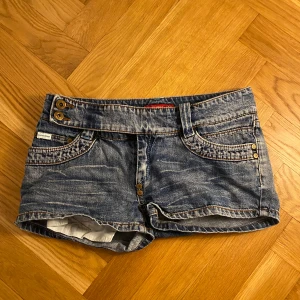 Mini jeansshorts med glitter - Snygga lågmidjade jeansshorts med glitter på ena bakfickan. 