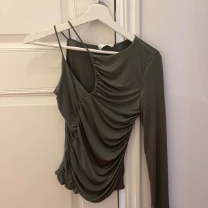 Grön One Shoulder top från Mango - Top i jättefin olivgrön färg, används endast enstaka gånger. Storlek S 