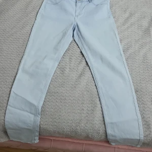 Ljusblå jeans - Snygga ljusblå jeans med en klassisk femficksdesign. De har en rak passform och är perfekta för en avslappnad stil. Jeansen har en knapp och dragkedja framtill.