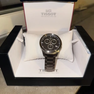 Silverfärgad klocka från Tissot - Snygg och stilren silverfärgad klocka från Tissot med metallarmband och tre sub-dials på urtavlan. Perfekt för den som gillar en klassisk och tidlös design. Levereras i originalförpackning. Pris kan diskuteras.