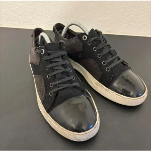 Lanvins - Snygga svarta lanvins med en glansig tå och snörning. Skorna har en kontrasterande vit sula och är tillverkade i mocka och syntetmaterial. Perfekta för en stilren look.